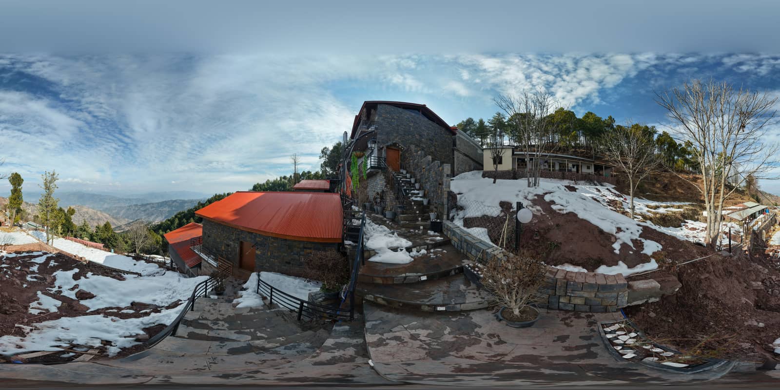A live Virtulee 360° tour of a mountain property with stone buildings and snow.